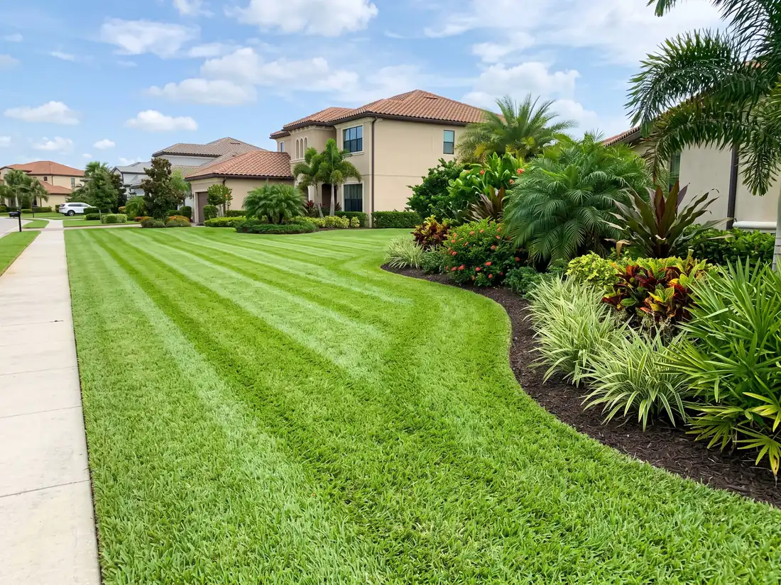 Landscape crew maintaining a manicured Florida lawn and planting beds